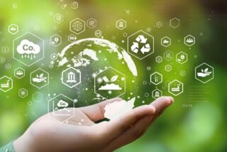 Symbolbild für Nachhaltigkeit: Hand hält eine digitale Weltkugel mit Icons zu CO₂, Recycling und Umwelt