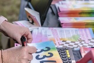 Startnummernvorbereitung mit Filzstift am Infostand des Förderturm-Firmenlaufs 2023