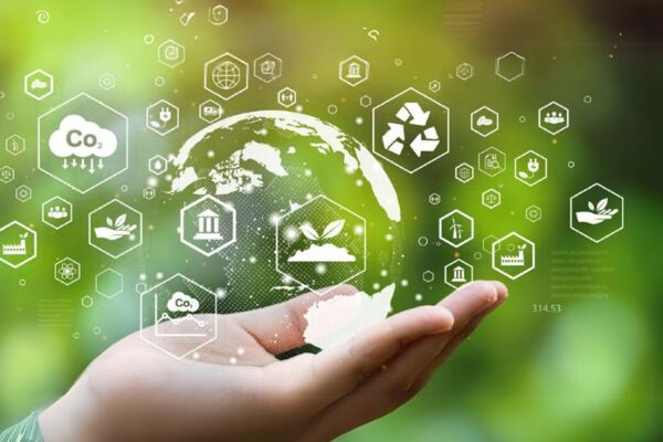 Symbolbild für Nachhaltigkeit: Hand hält eine digitale Weltkugel mit Icons zu CO₂, Recycling und Umwelt